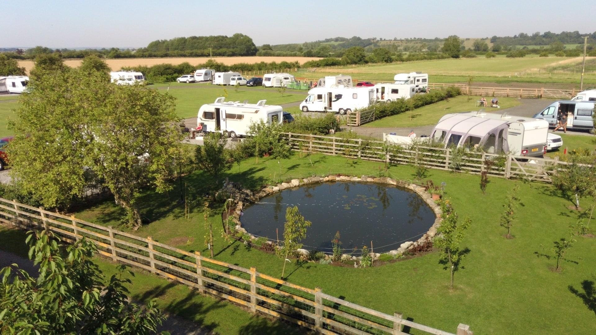 A view of the caravan park and lake with caravans and motorhomes.